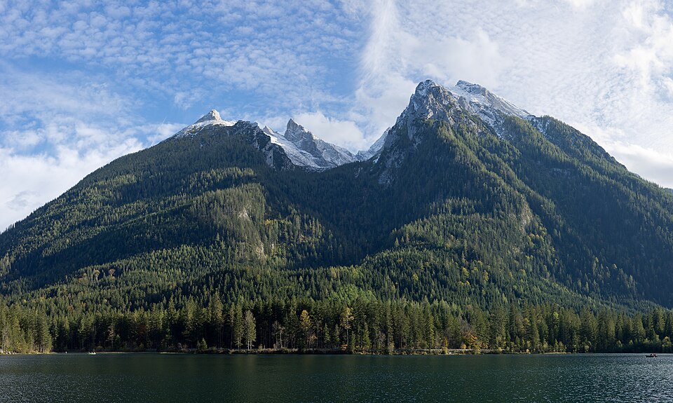 The calm Hintersee lake near Ramsau with forested slopes and the snow-dusted Hochkalter massif behind.